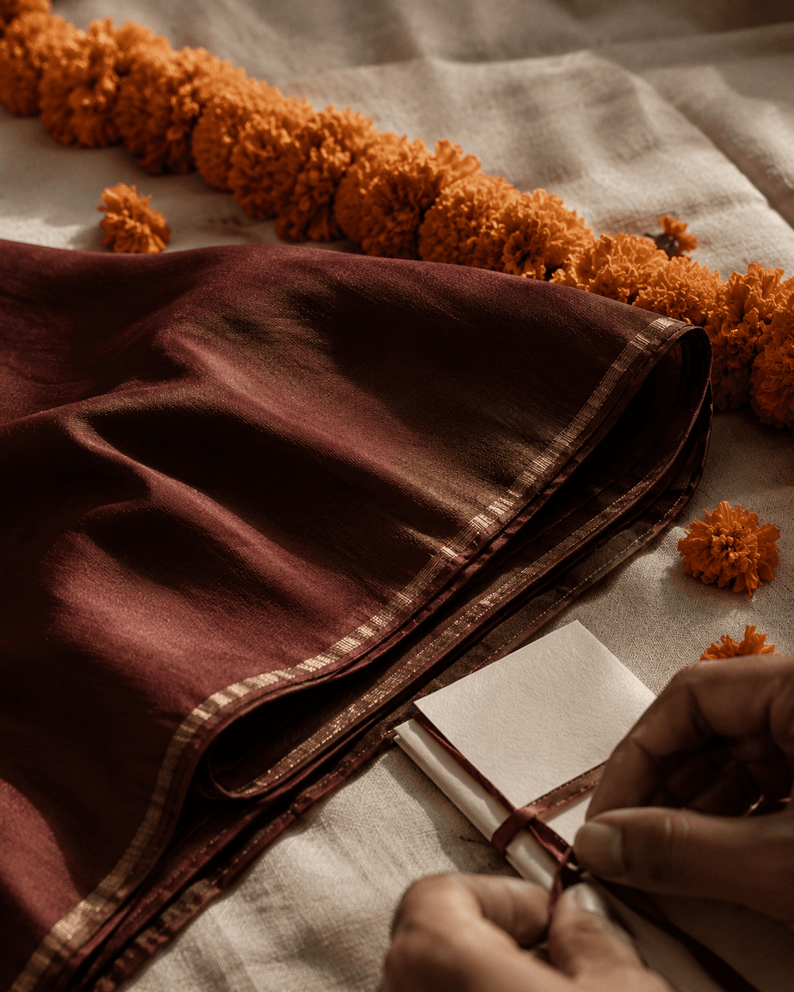 Folded oxblood silk with marigold and a hand tying ribbon